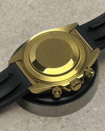 PB TimePiece Riviera chronograph watch showing the gold case back, pushers, and black rubber strap.