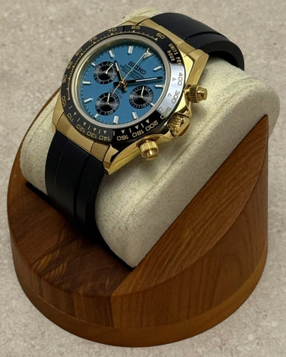PB TimePiece Riviera chronograph watch with a turquoise dial, gold 39mm case, black bezel, and black rubber strap.