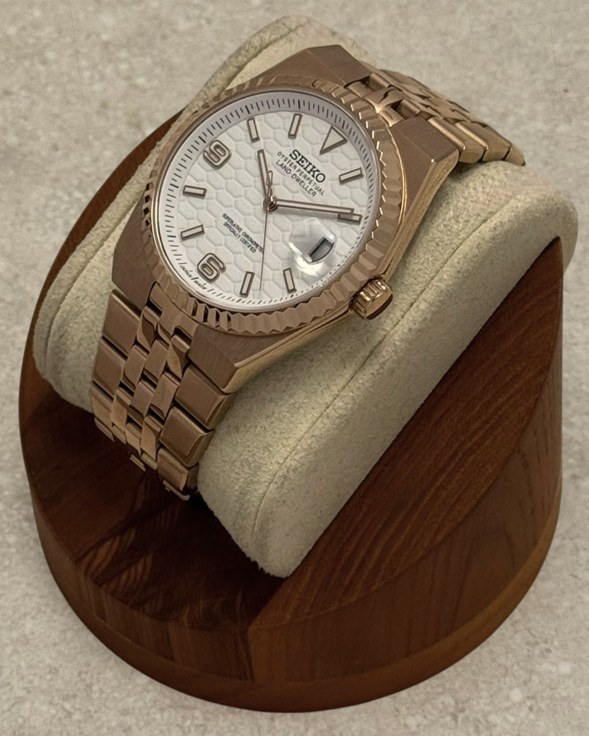 PB TimePiece Honeycomb watch with rose gold jubilee bracelet, fluted bezel, and white textured dial on display stand.