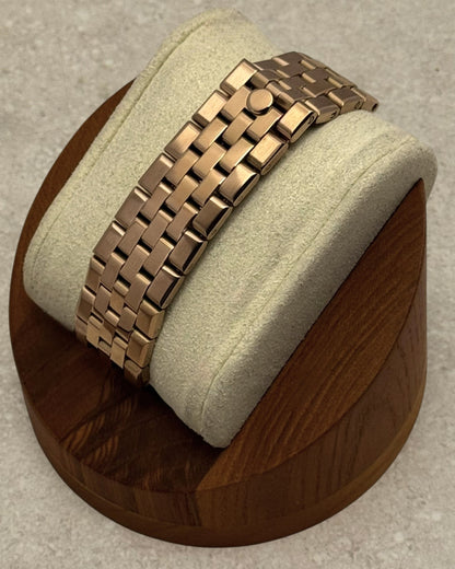 PB TimePiece Honeycomb watch featuring a rose gold jubilee bracelet with a hidden clasp on a wooden display stand.