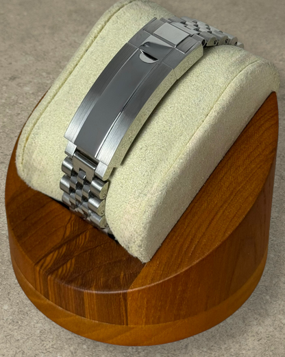 PB TimePiece Classic Date watch stainless steel jubilee bracelet with microadjusting clasp on a wooden display stand