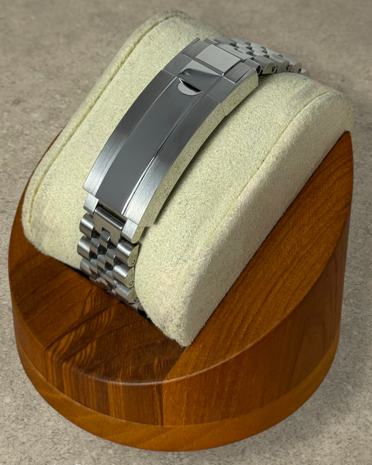 PB TimePiece stainless steel jubilee watch bracelet with microadjusting clasp on a wooden display stand
