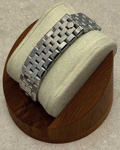 PB TimePiece stainless steel flat jubilee bracelet with hidden clasp on a watch display stand