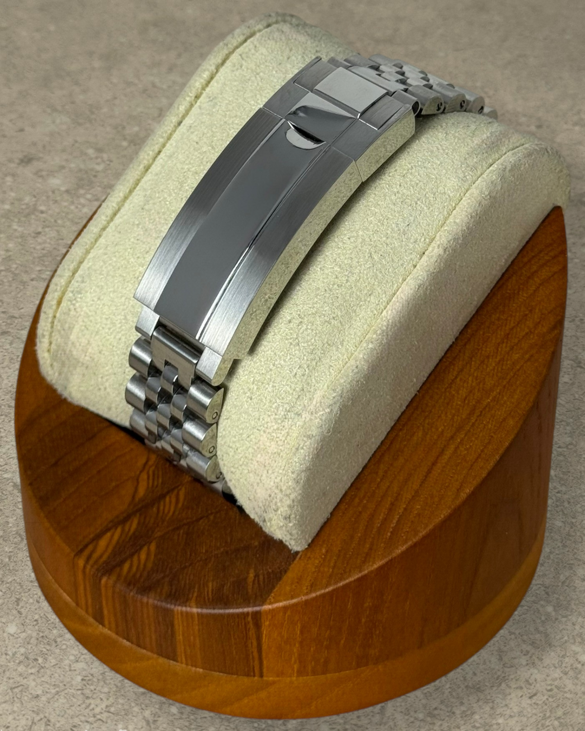 PB TimePiece stainless steel jubilee watch bracelet with micro-adjusting clasp on a wooden display stand