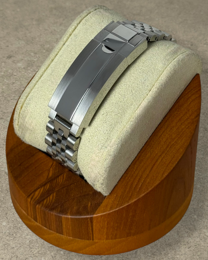 PB TimePiece stainless steel jubilee watch bracelet with microadjusting clasp on a wooden display stand
