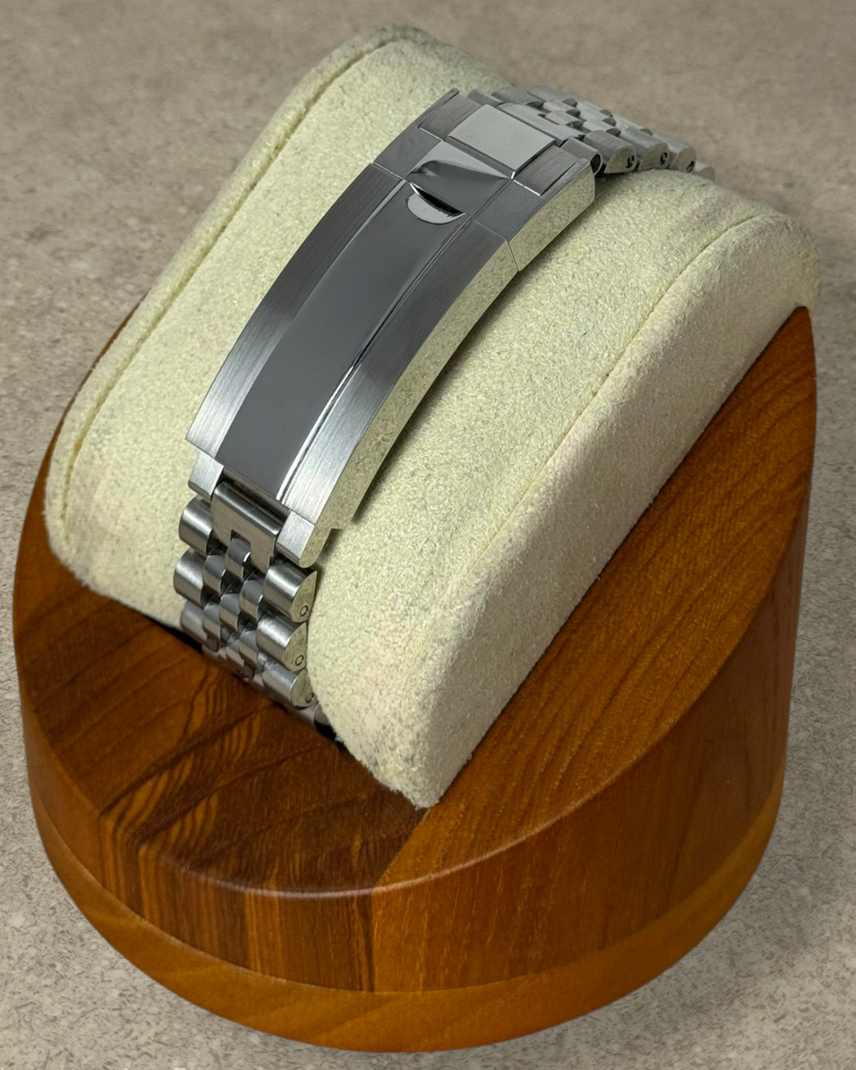 PB TimePiece stainless steel jubilee watch bracelet with microadjusting clasp on a wooden display stand