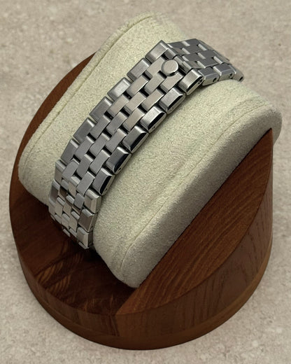 PB TimePiece stainless steel jubilee bracelet with hidden clasp on a wooden watch display stand