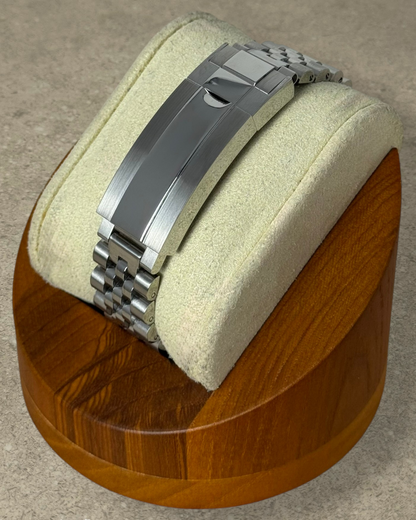 PB TimePiece stainless steel jubilee watch bracelet with microadjusting clasp on a wooden display stand