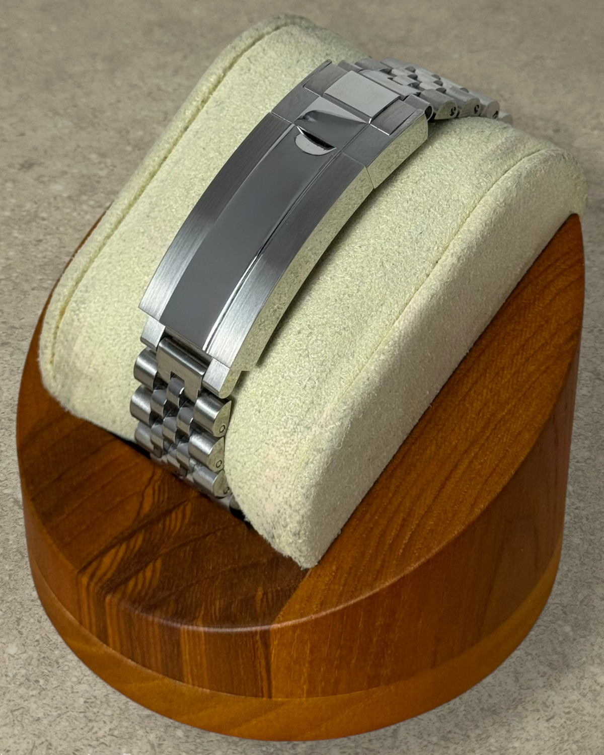 PB TimePiece stainless steel jubilee watch bracelet with microadjusting clasp on a wooden display stand