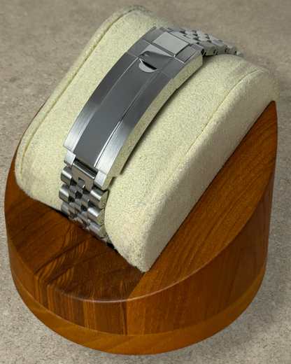 PB TimePiece stainless steel jubilee watch bracelet with microadjusting clasp on a wooden display stand