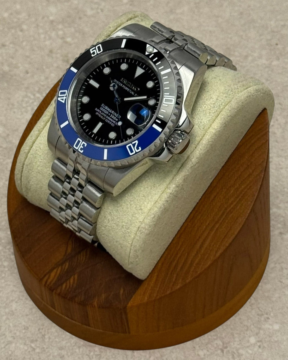 PB TimePiece Submariner Batman watch with black and blue rotating bezel, black dial, and stainless steel bracelet.