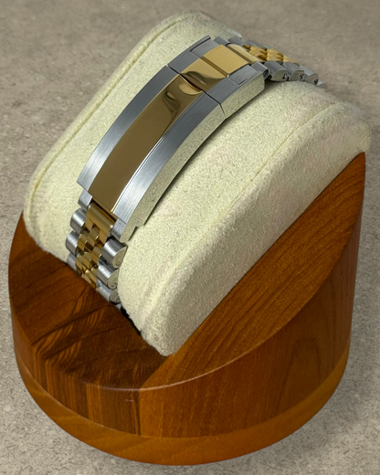 PB TimePiece two-tone gold Jubilee bracelet with microadjustable clasp on a watch display stand