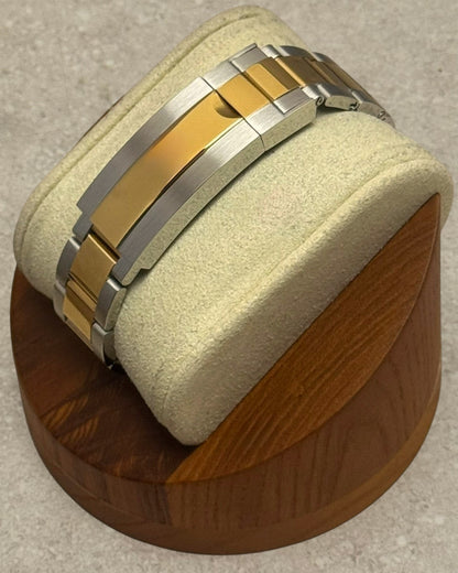 PB TimePiece two-tone gold and stainless steel oyster bracelet with microadjusting clasp on a display stand