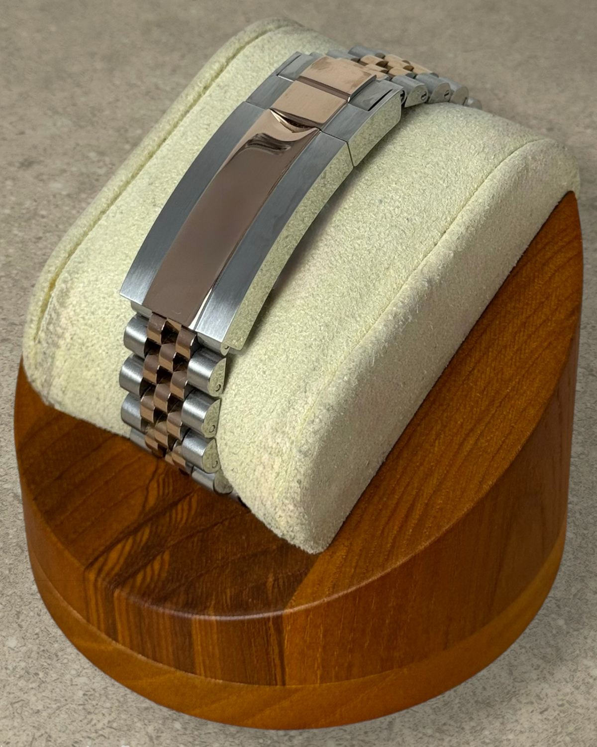 PB TimePiece two-tone rose gold and silver jubilee bracelet with microadjustable clasp on a wooden watch stand