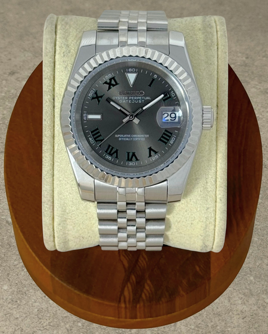 PB TimePiece Classic Date Wimbledon watch with gray dial, green Roman numerals, and stainless steel jubilee bracelet.