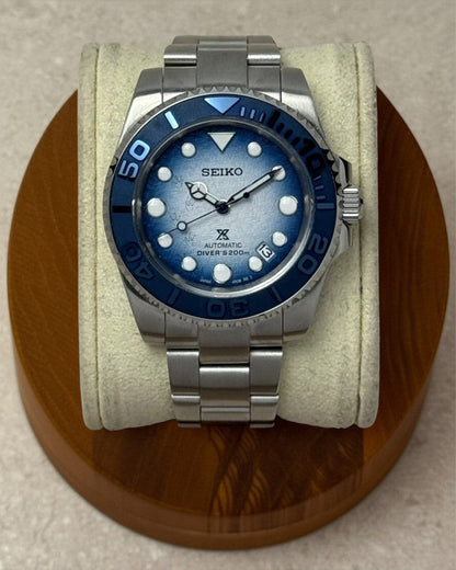 PB TimePiece Yachtmaster Save The Ocean watch with a gradient blue dial, penguin footprints, and navy rotating bezel.