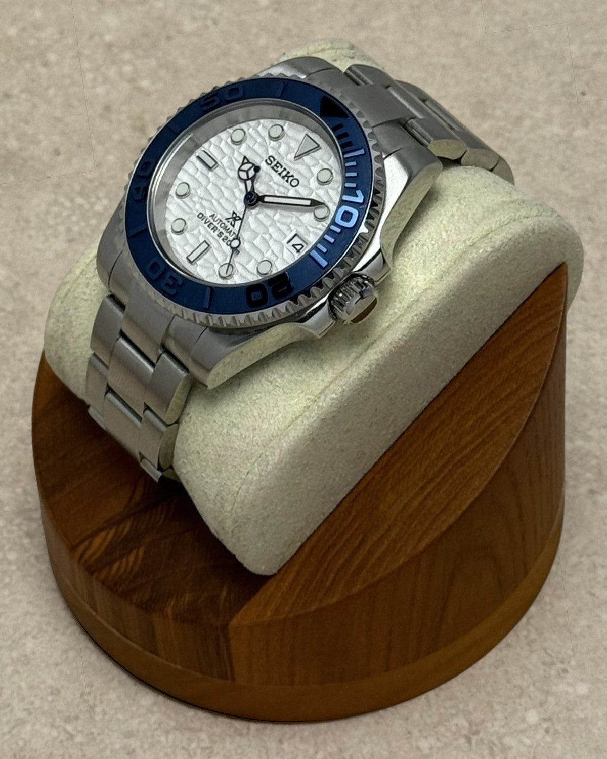 PB TimePiece Yachtmaster watch with a white wave-textured dial, navy blue rotating bezel, and stainless steel band.