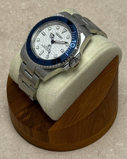 PB TimePiece Yachtmaster watch with a white wave-textured dial, navy blue rotating bezel, and stainless steel band.